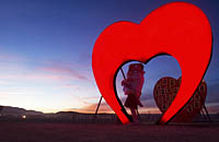 People kissing under Red Heart Burning Man installation