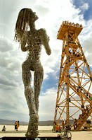 Sculpture of woman looking up the oil tower