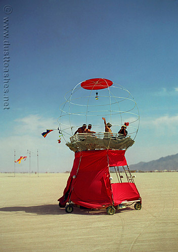 people riding the bubblegum machine vehicle accross playa