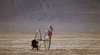 women playing on teeter totter in desert