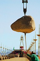 Man pulling one of the suspended Colossus stones