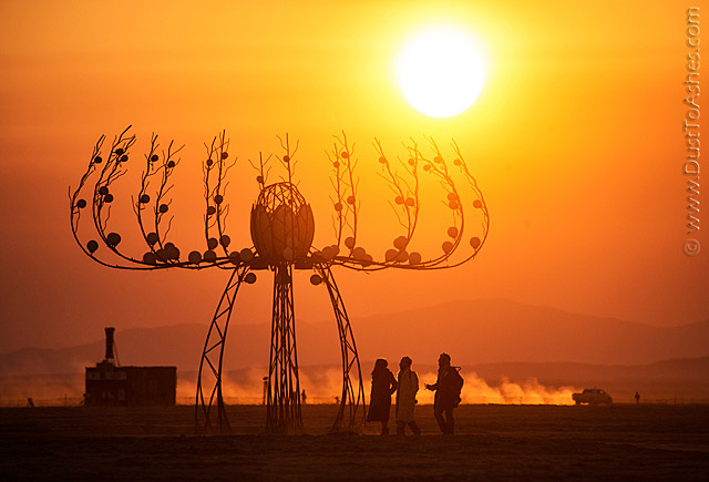 Silhouettes of Burning Man people in the morning sunrise