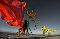 Dancing girls in front of the spinning wheels by PDA. Windmills art installation.