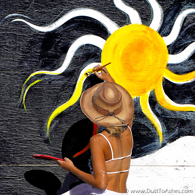 Woman painting the picture of Sun on center camp fence