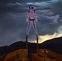 Neon art sculpture standing tall in front of the dark sky